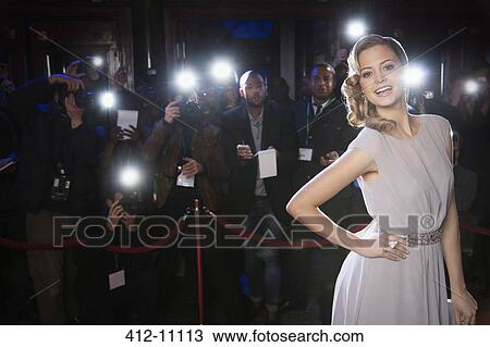 Portrait of well dressed female celebrity at red carpet event with paparazzi in background View Large Photo Image Stock Image - Portrait of well dressed female celebrity at red carpet event with paparazzi in background. Fotosearch