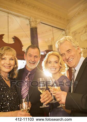 Portrait of well dressed friends drinking champagne in theater lobby View Large Photo Image Stock Image - Portrait of well dressed friends drinking champagne in theater lobby. Fotosearch