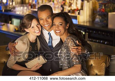 Portrait of well dressed friends hugging in luxury bar View Large Photo Image Stock Photo - Portrait of well dressed friends hugging in luxury bar. Fotosearch