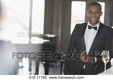 Portrait of well dressed man drinking cocktail in lounge View Large Photo Image Stock Image - Portrait of well dressed man drinking cocktail in lounge. Fotosearch