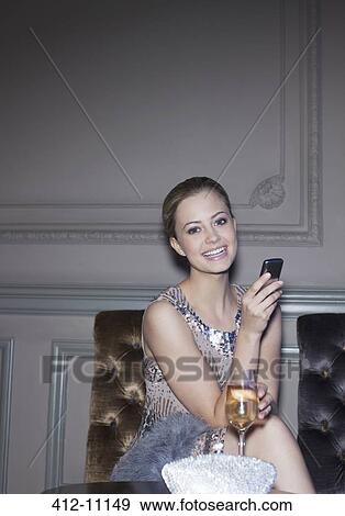 Portrait of well dressed woman drinking champagne and using cell phone View Large Photo Image Stock Photo - Portrait of well dressed woman drinking champagne and using cell phone. Fotosearch