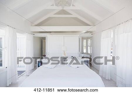 Rafters above bed in white bedroom View Large Photo Image Stock Image - Rafters above bed in white bedroom. Fotosearch
