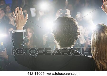 Picture - Rear view of celebrity couple waving to paparazzi. Fotosearch
