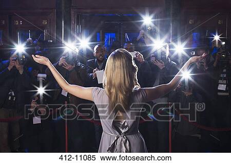 Rear view of female celebrity with arms outstretched to paparazzi at red carpet event View Large Photo Image Stock Photography - Rear view of female celebrity with arms outstretched to paparazzi at red carpet event. Fotosearch