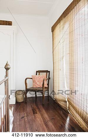 Stock Image - Reed curtains and armchair in bedroom. Fotosearch