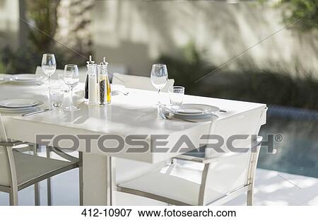 Set dining table on modern patio at poolside View Large Photo Image Stock Photo - Set dining table on modern patio at poolside. Fotosearch