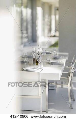 Stock Photograph - Set dining table on modern patio. Fotosearch