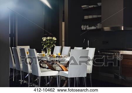 Stock Image - Set table in modern dining room. Fotosearch