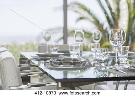 Stock Image - Set table in modern dining room. Fotosearch