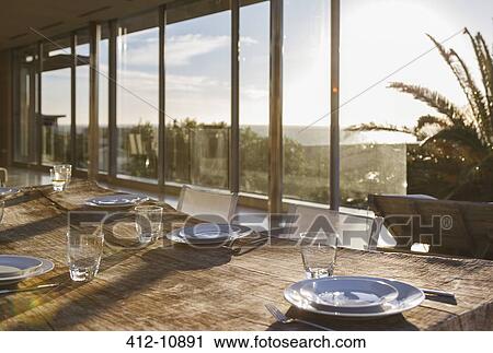 Stock Image - Set table in modern dining room. Fotosearch
