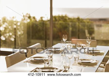 Stock Image - Set table in modern dining room. Fotosearch