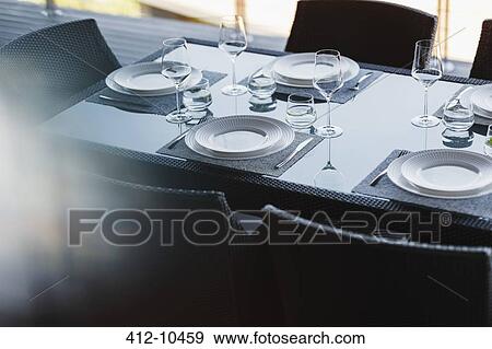 Stock Photo - Set table in modern dining room. Fotosearch