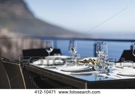 Stock Image - Set table on modern patio. Fotosearch