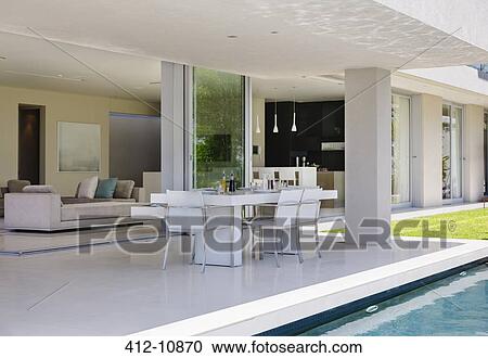 Set table on patio by pool of modern house View Large Photo Image Stock Image - Set table on patio by pool of modern house. Fotosearch