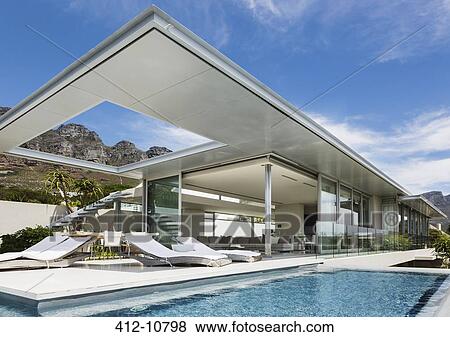 Stock Photo - Swimming pool and patio outside modern house. Fotosearch