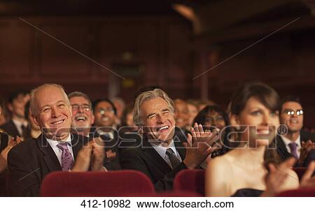Stock Image - Theater audience laughing and clapping. Fotosearch