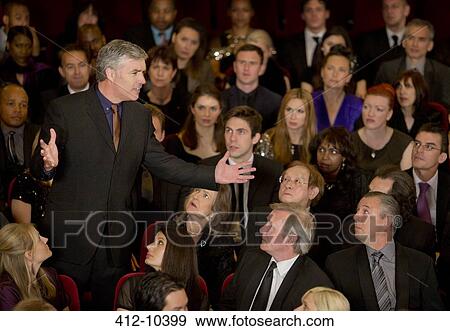 Theater audience watching standing man gesturing View Large Photo Image Stock Photo - Theater audience watching standing man gesturing. Fotosearch