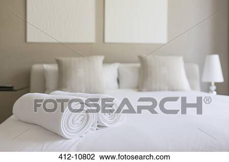 Stock Image - Towels on bed in bedroom. Fotosearch