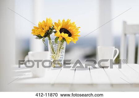 Vase of flowers and coffee cups on kitchen table View Large Photo Image Stock Image - Vase of flowers and coffee cups on kitchen table. Fotosearch