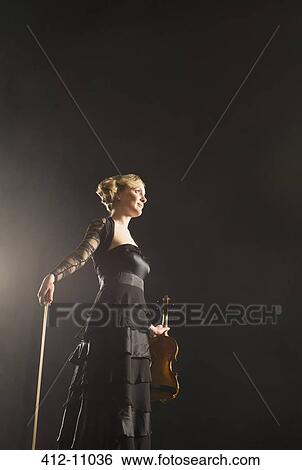 Violinist posing on theater stage View Large Photo Image Stock Photograph - Violinist posing on theater stage. Fotosearch