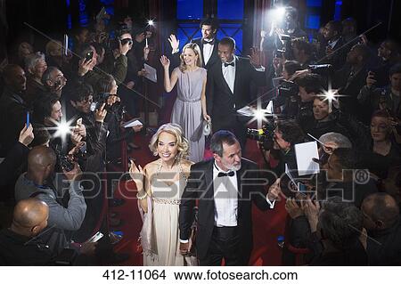 Picture - Well dressed celebrities waving to paparazzi on red carpet. Fotosearch