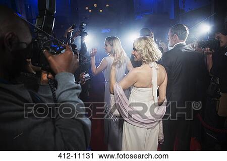 Well dressed celebrities waving to paparazzi on red carpet View Large Photo Image Stock Image - Well dressed celebrities waving to paparazzi on red carpet. Fotosearch
