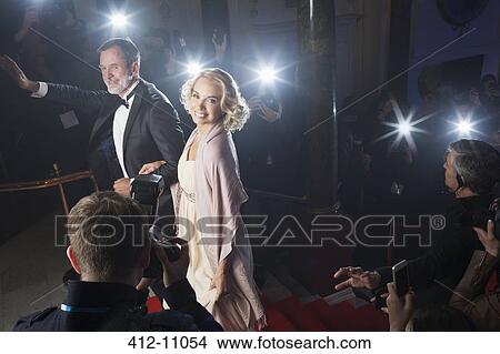 Well dressed celebrity couple waving to paparazzi on red carpet View Large Photo Image Picture - Well dressed celebrity couple waving to paparazzi on red carpet. Fotosearch