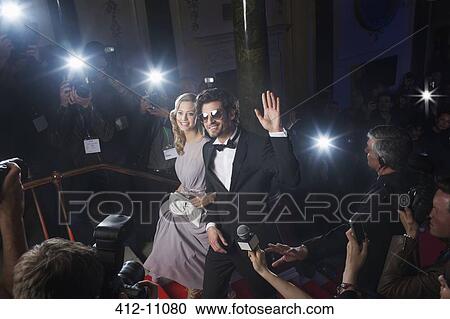 Well dressed celebrity couple waving to paparazzi on red carpet View Large Photo Image Stock Image - Well dressed celebrity couple waving to paparazzi on red carpet. Fotosearch