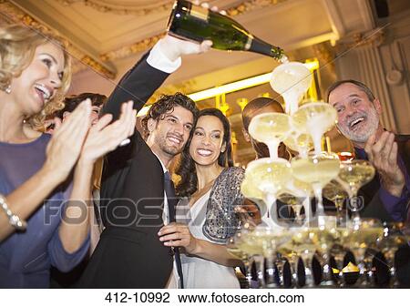 Well dressed couple pouring champagne pyramid View Large Photo Image Stock Image - Well dressed couple pouring champagne pyramid. Fotosearch
