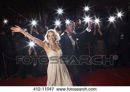 Well dressed couple waving to paparazzi on red carpet View Large Photo Image Stock Photo - Well dressed couple waving to paparazzi on red carpet. Fotosearch