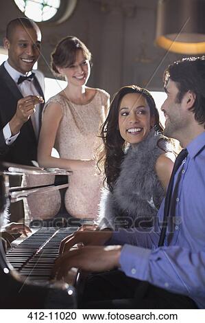 Well dressed friends playing piano in luxury nightclub View Large Photo Image Stock Image - Well dressed friends playing piano in luxury nightclub. Fotosearch