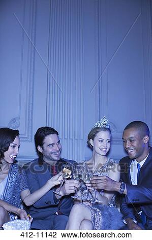 Well dressed friends toasting champagne flutes View Large Photo Image Stock Image - Well dressed friends toasting champagne flutes. Fotosearch