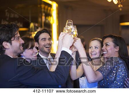 Well dressed friends toasting champagne flutes View Large Photo Image Stock Photo - Well dressed friends toasting champagne flutes. Fotosearch