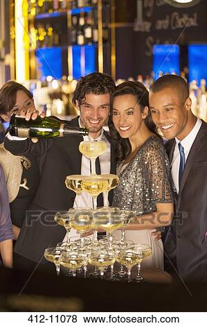 Well dressed man pouring champagne pyramid View Large Photo Image Stock Photo - Well dressed man pouring champagne pyramid. Fotosearch
