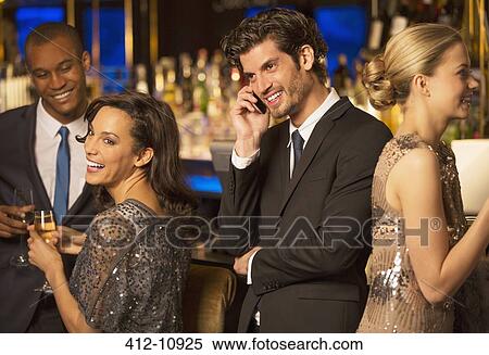 Well dressed man talking on cell phone in luxury bar View Large Photo Image Stock Photography - Well dressed man talking on cell phone in luxury bar. Fotosearch