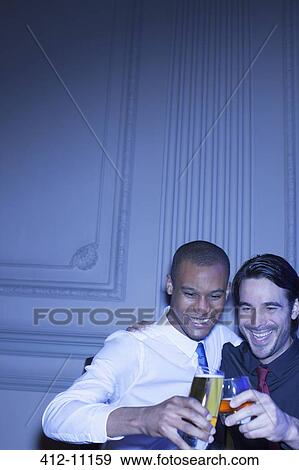 Stock Photo - Well dressed men hugging and toasting beer and cocktail. Fotosearch