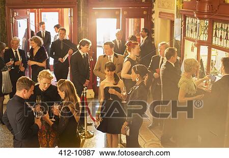 Well dressed people drinking champagne in theater lobby View Large Photo Image Stock Photo - Well dressed people drinking champagne in theater lobby. Fotosearch