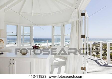 Stock Image - White bedroom overlooking ocean. Fotosearch