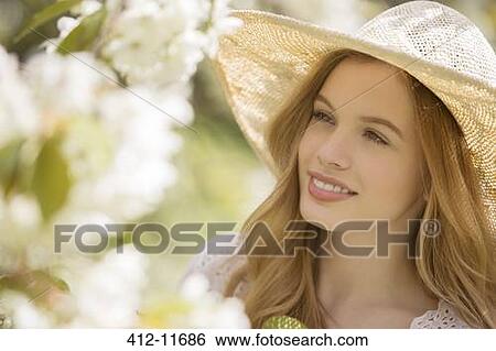 Woman admiring flowers outdoors View Large Photo Image Stock Photograph - Woman admiring flowers outdoors. Fotosearch