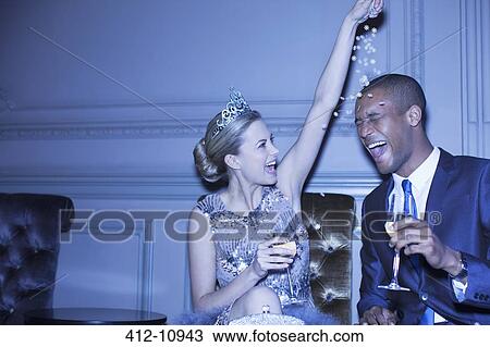 Woman in tiara sprinkling confetti over man View Large Photo Image Stock Image - Woman in tiara sprinkling confetti over man. Fotosearch