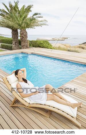 Woman relaxing by pool View Large Photo Image Stock Photo - Woman relaxing by pool. Fotosearch