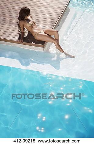 Woman relaxing by swimming pool View Large Photo Image Stock Photo - Woman relaxing by swimming pool. Fotosearch