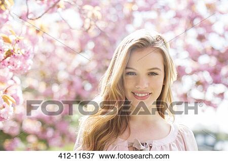 Woman smiling under tree with pink blossoms View Large Photo Image Stock Photo - Woman smiling under tree with pink blossoms. Fotosearch