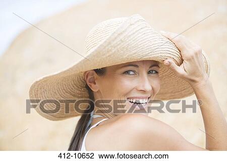 Woman wearing straw hat on beach View Large Photo Image Stock Image - Woman wearing straw hat on beach. Fotosearch