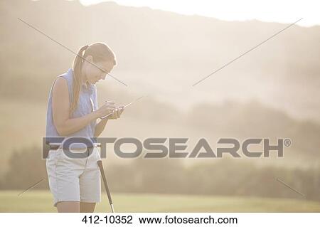 Woman with scorecard on golf course View Large Photo Image Stock Image - Woman with scorecard on golf course. Fotosearch
