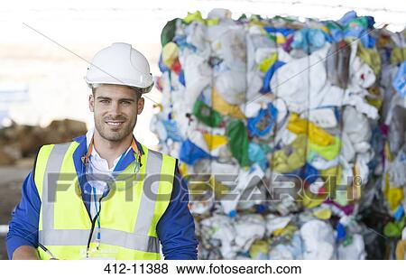 Stock Photo - Worker smiling in recycling center. Fotosearch