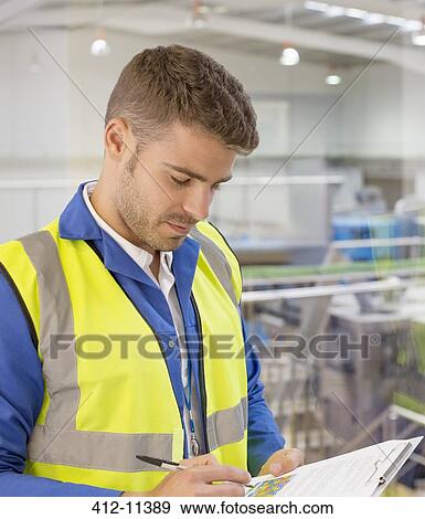 Worker with clipboard in factory View Large Photo Image Stock Photo - Worker with clipboard in factory. Fotosearch