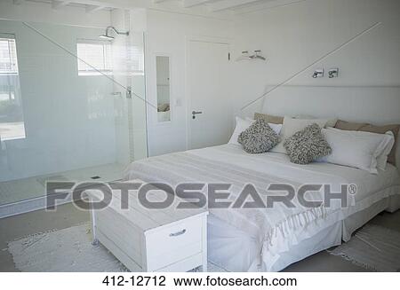 Stock Image - Bed, shower and trunk in modern bedroom. Fotosearch