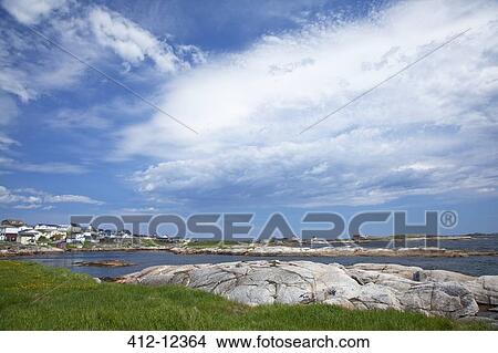 Picture - Blue sky and clouds over craggy harbor. Fotosearch