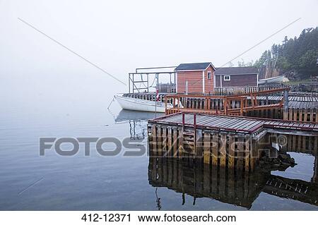 Stock Image - Boathouses and dock on bay. Fotosearch